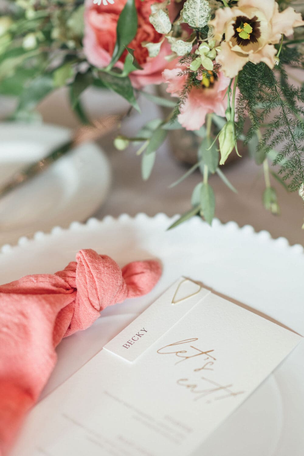 Banquet style table setting with coral linen and candlelight inside Wenmans Barn at Caswell House Oxfordshire, summer wedding photography by Hannah McClune Photography