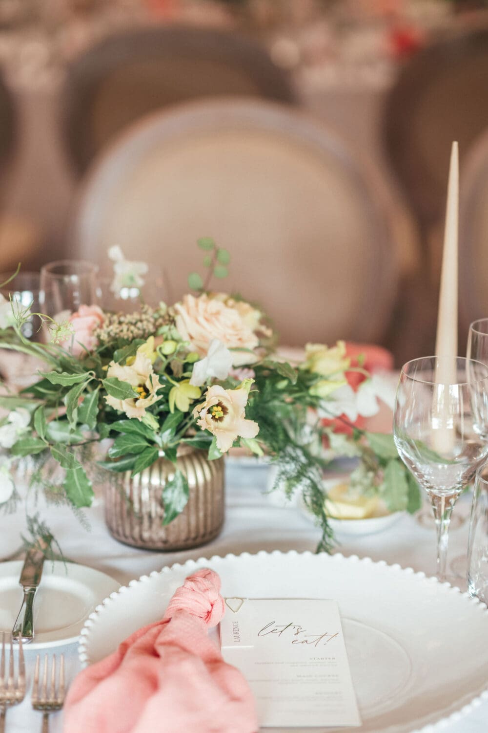 Banquet style table setting with coral linen and candlelight inside Wenmans Barn at Caswell House Oxfordshire, summer wedding photography by Hannah McClune Photography
