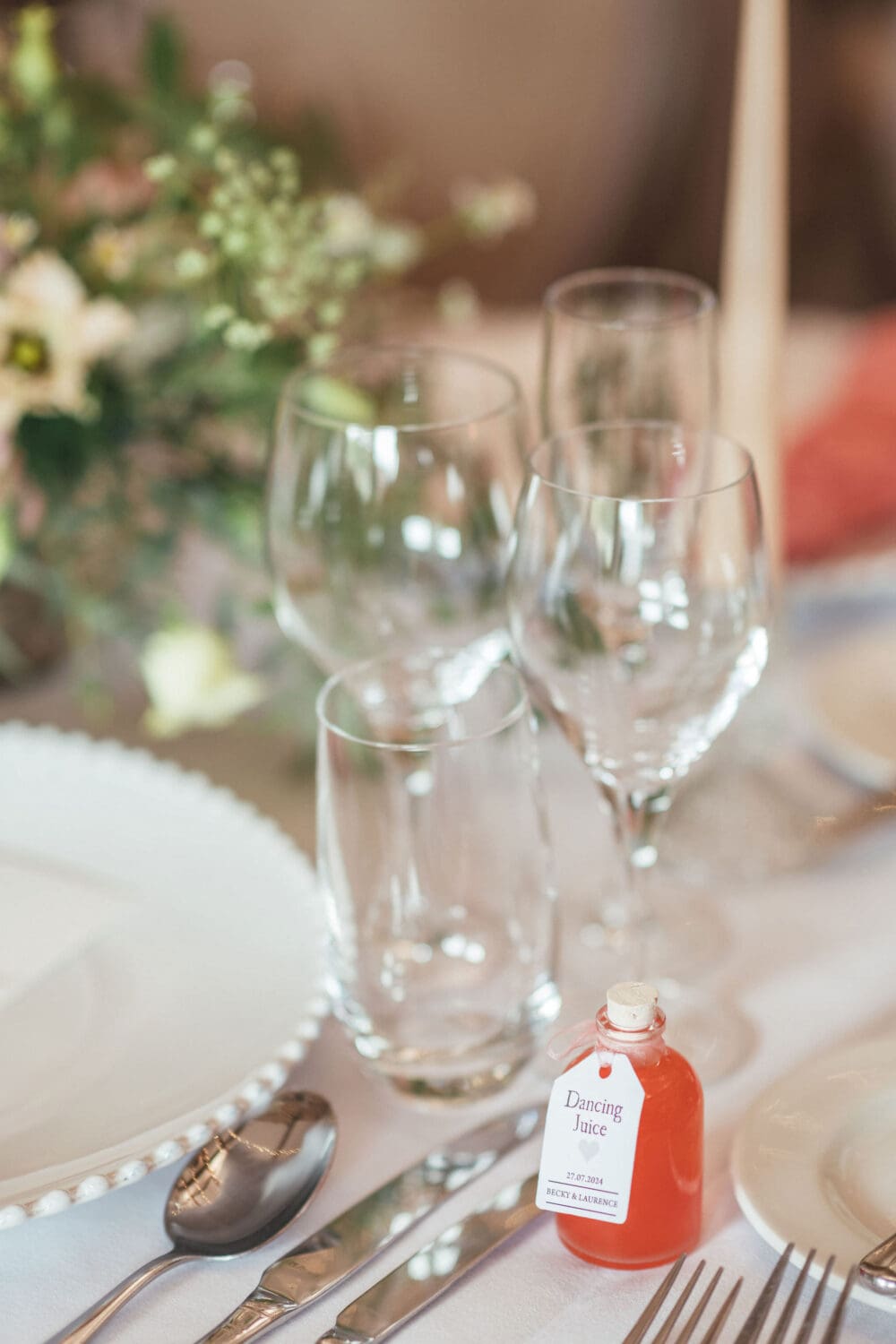 Banquet style table setting with coral linen and candlelight inside Wenmans Barn at Caswell House Oxfordshire, summer wedding photography by Hannah McClune Photography